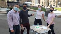 Member of the Mor Lab celebrate by the Hammer Science building wearing masks.